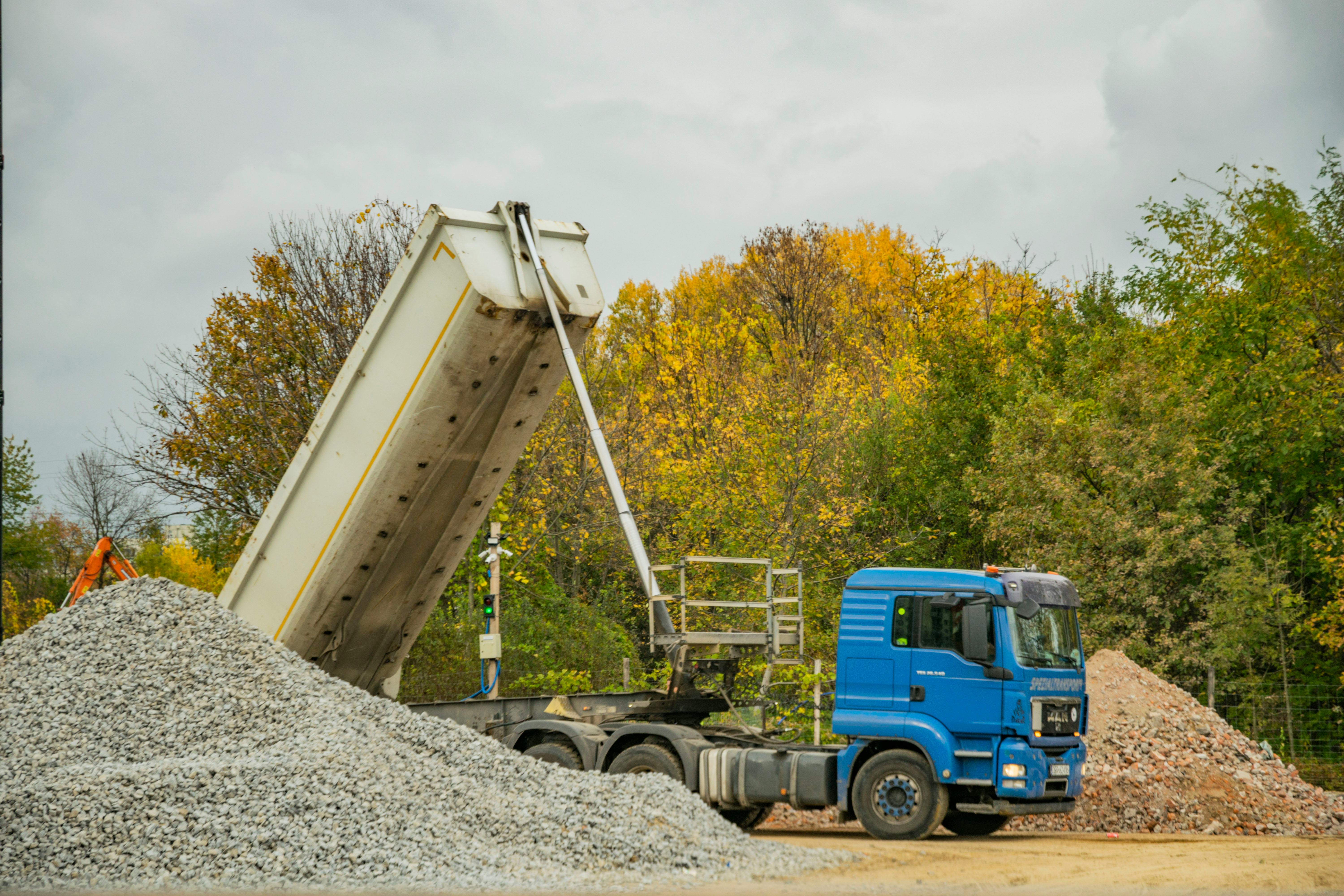 Dump trailer unloading crushed aggregate at site